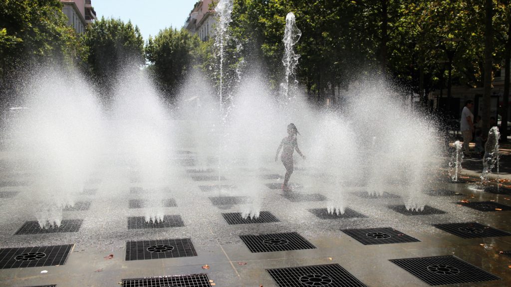 Kid splashing at a water fountain in Antibes (France)